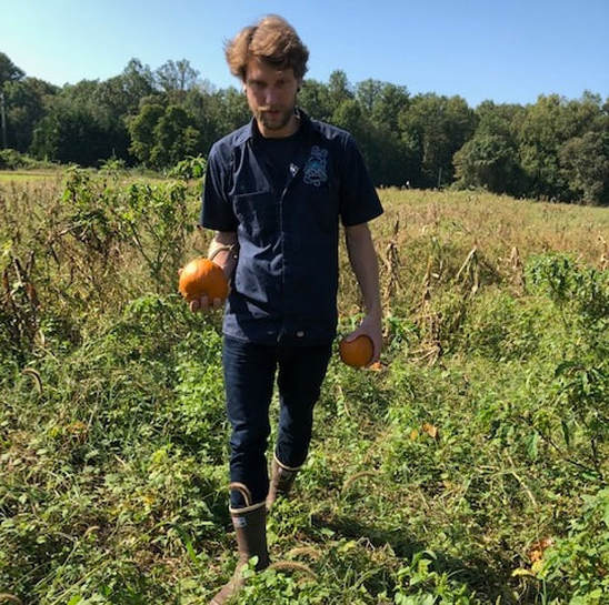 Adam the Jedi Master head brewer holding pumpkins and walking through a field looking glorious